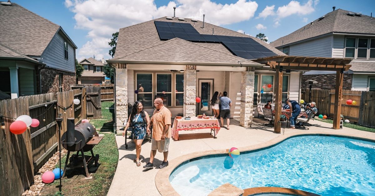 A backyard with a pool and solar panels on the roof